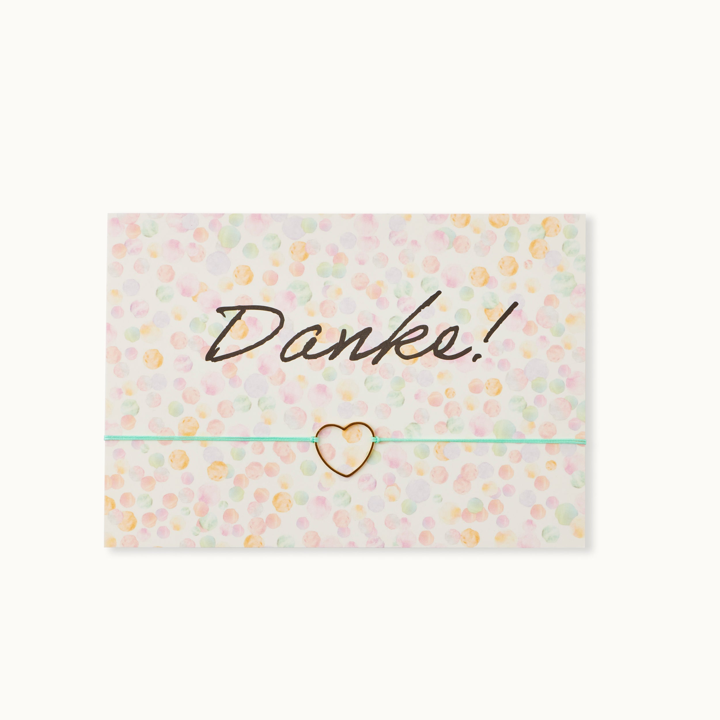 Danke! Karte mit einem Herz als 18K vergoldeter Anhänger an einem türkisfarbenen Armband.