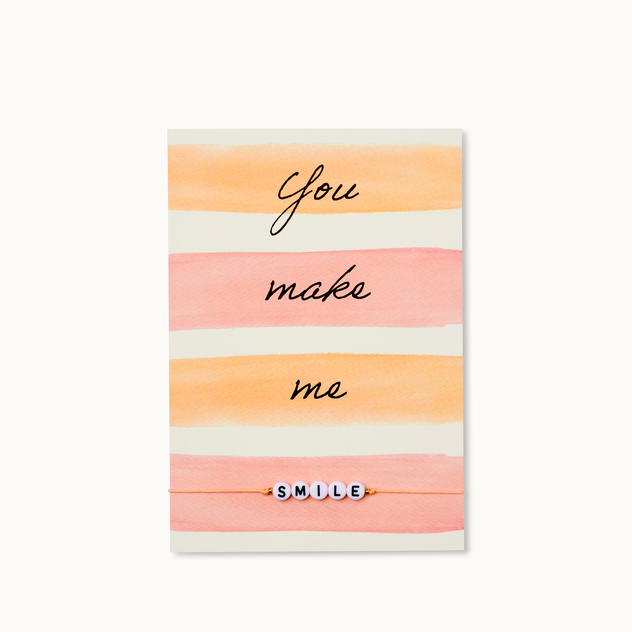 You make me Happy! Karte mit Schriftzug SMILE aus Acrylperlen mit zwei 18K vergoldeten Perlen an einem lachsfarbenen Armband. 