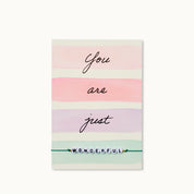 Eine besondere Grußkarte mit einem Schriftzug WONDERFUL aus Acrylperlen mit zwei 18K vergoldeten Perlen an einem dunkelgrünen Armband.