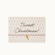 Sweet Christmas! Karte mit einer Zuckerstange als 18K vergoldeter Anhänger an einem dunkelroten Armband.