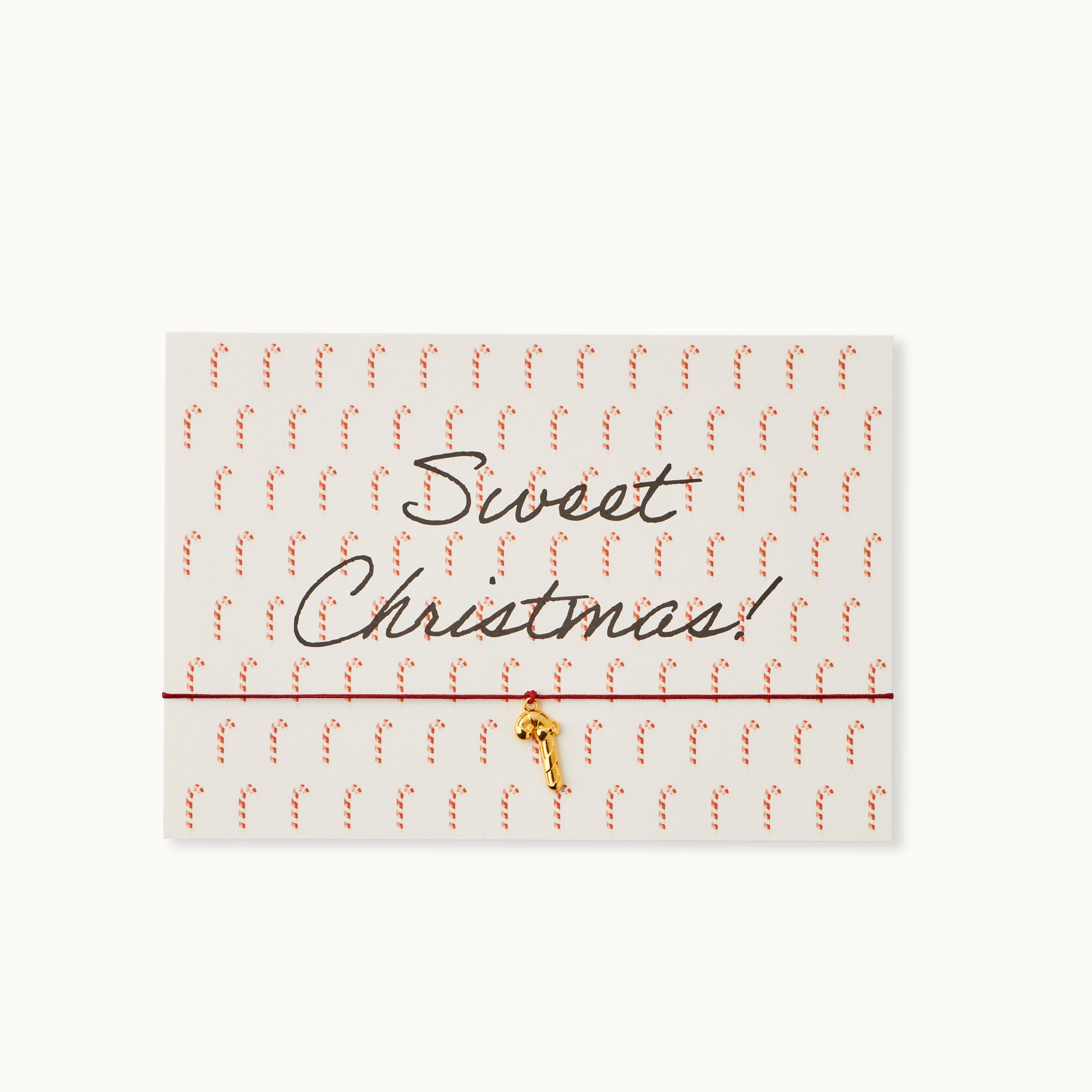 Sweet Christmas! Karte mit einer Zuckerstange als 18K vergoldeter Anhänger an einem dunkelroten Armband.